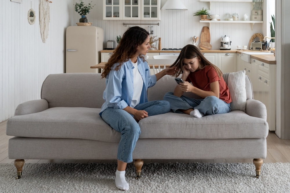 Parent supporting a child at home during a difficult moment involving a phone